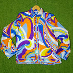 Colorful patterned jacket on a hanger against a green background