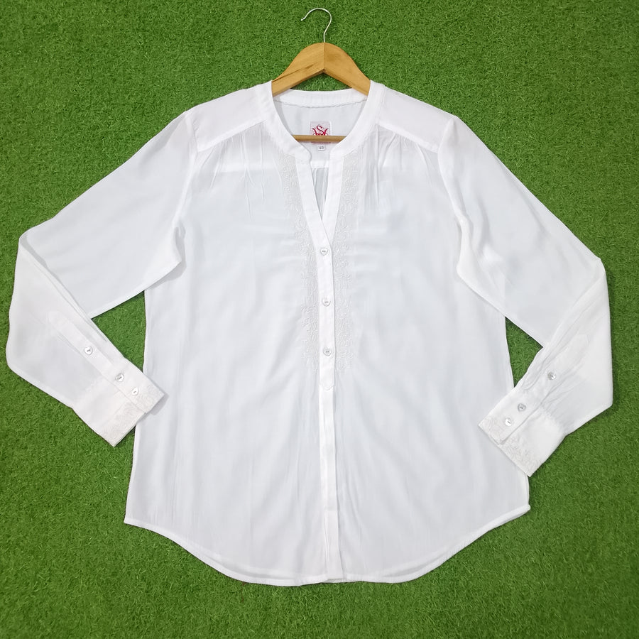 White shirt on a hanger against a green background