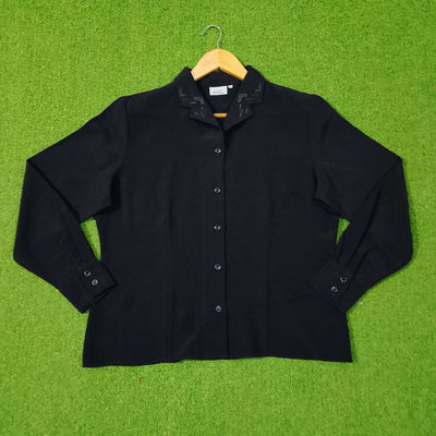 Black shirt on a hanger against a green grass-like background