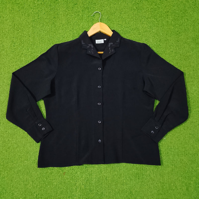 Black shirt on a hanger against a green grass-like background
