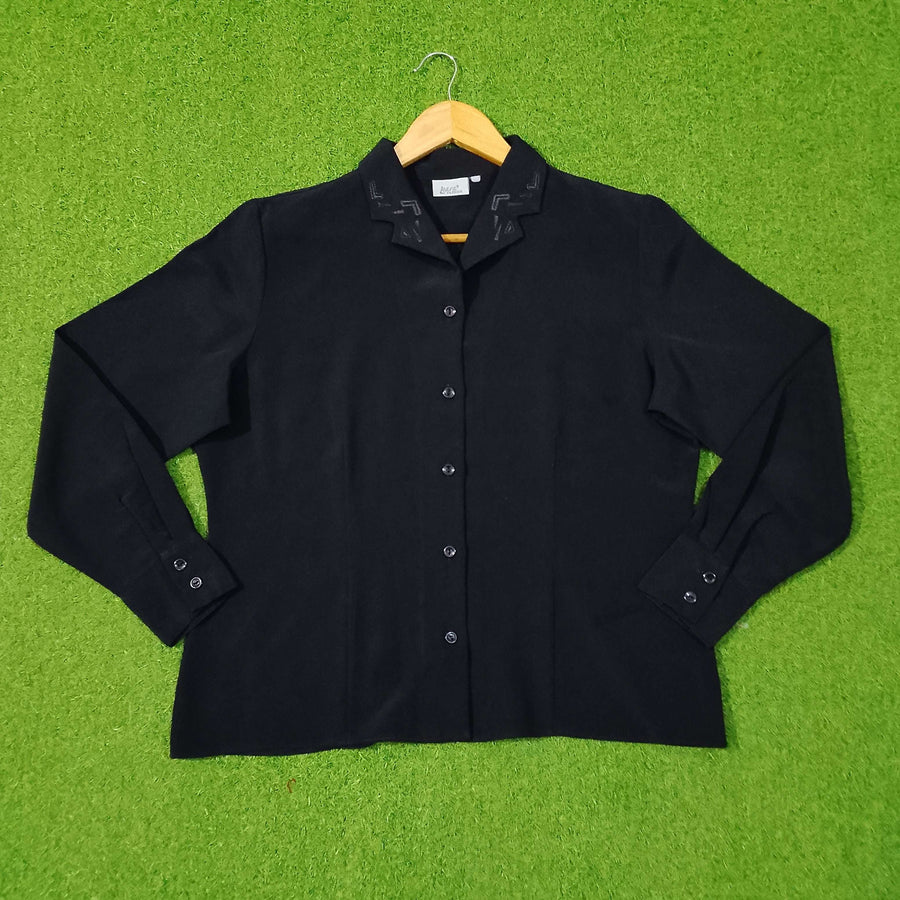 Black shirt on a hanger against a green grass-like background