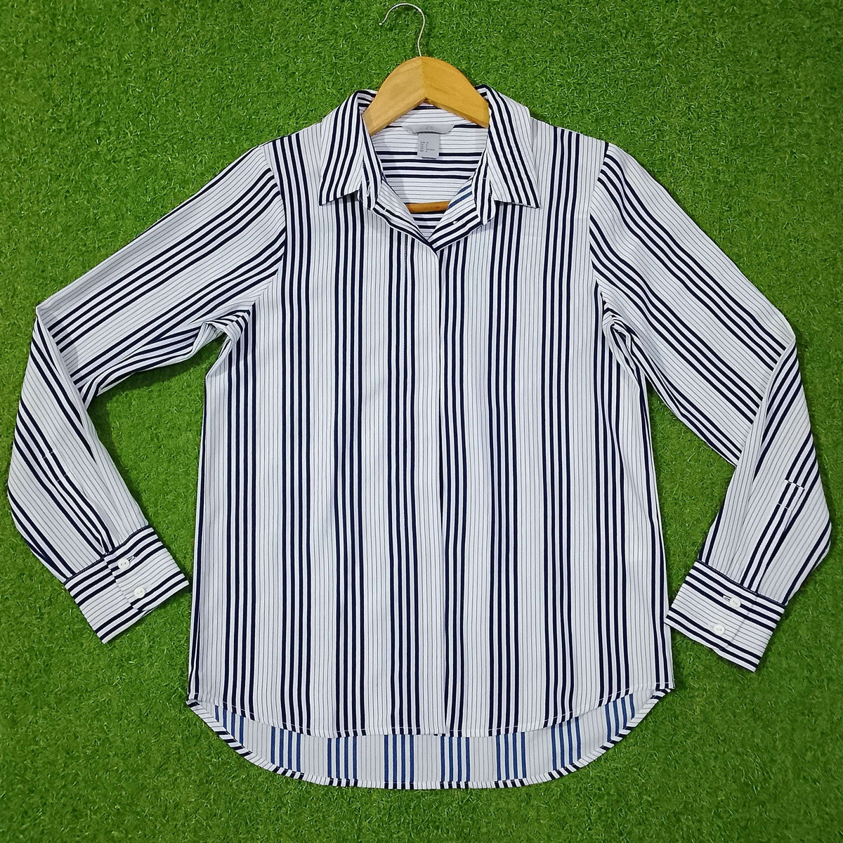 Striped shirt on a hanger against a green background