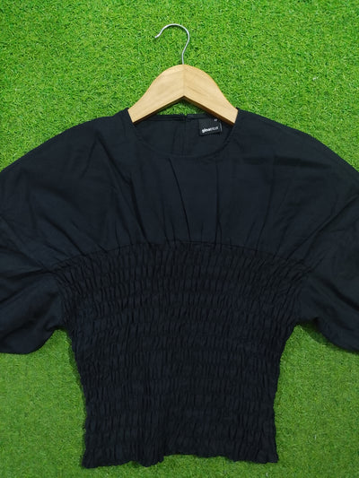 Black smocked drop shoulder flared sleeve crop top - front view on hanger