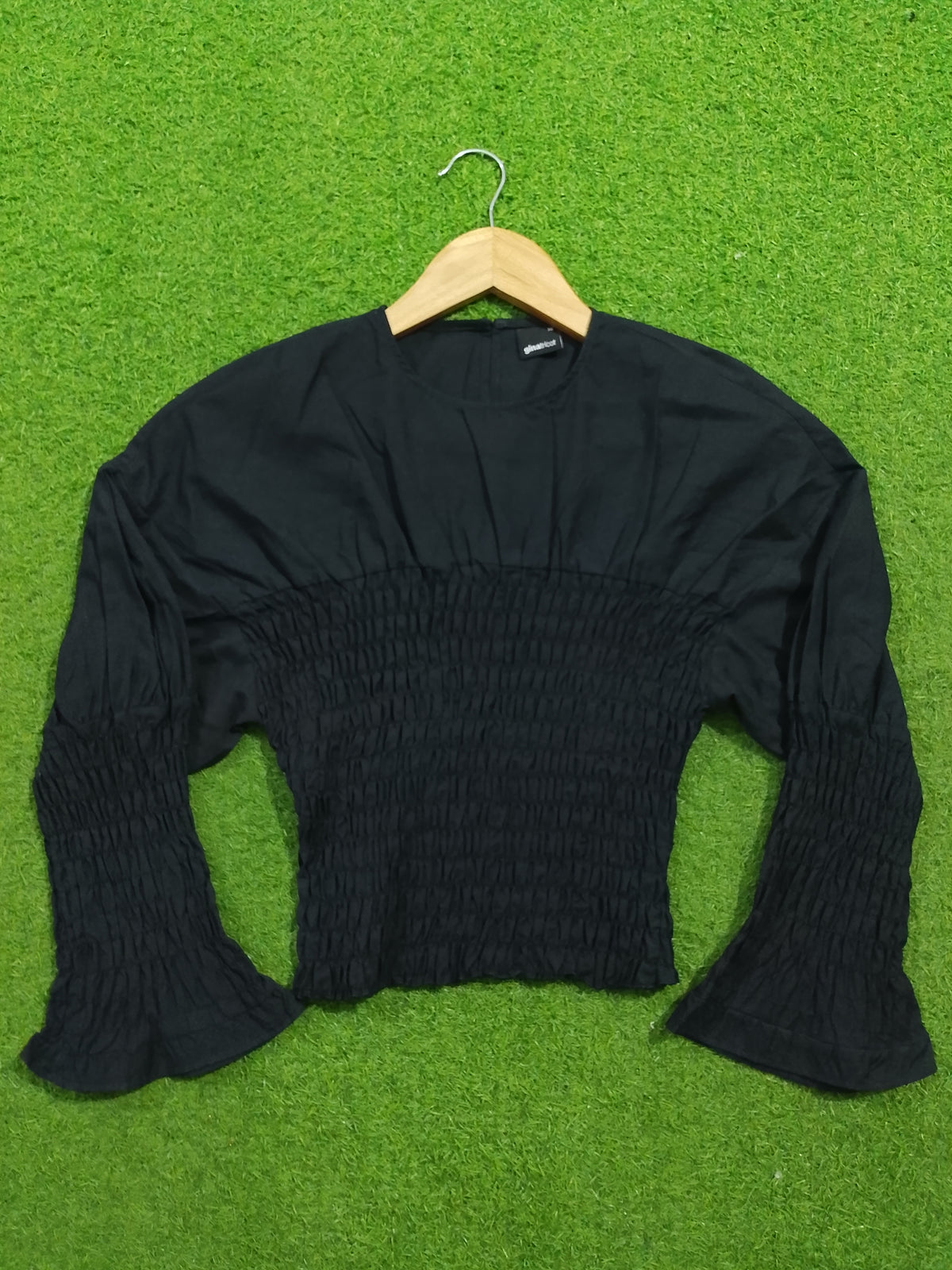 Black smocked drop shoulder flared sleeve crop top - full front flat lay