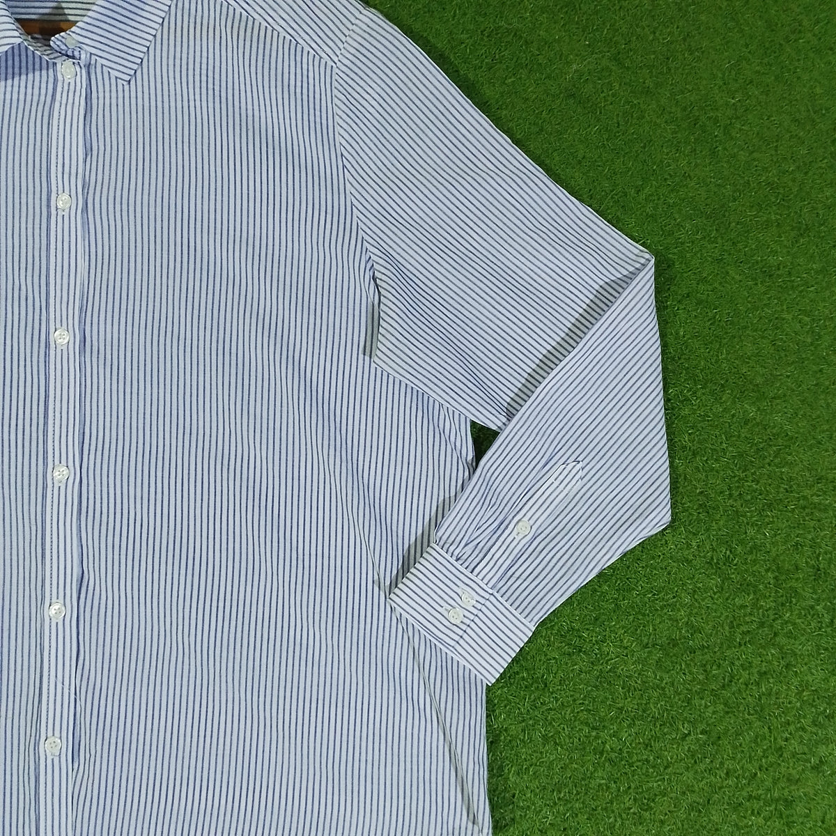 Close-up of white and navy pinstripe shirt with button front