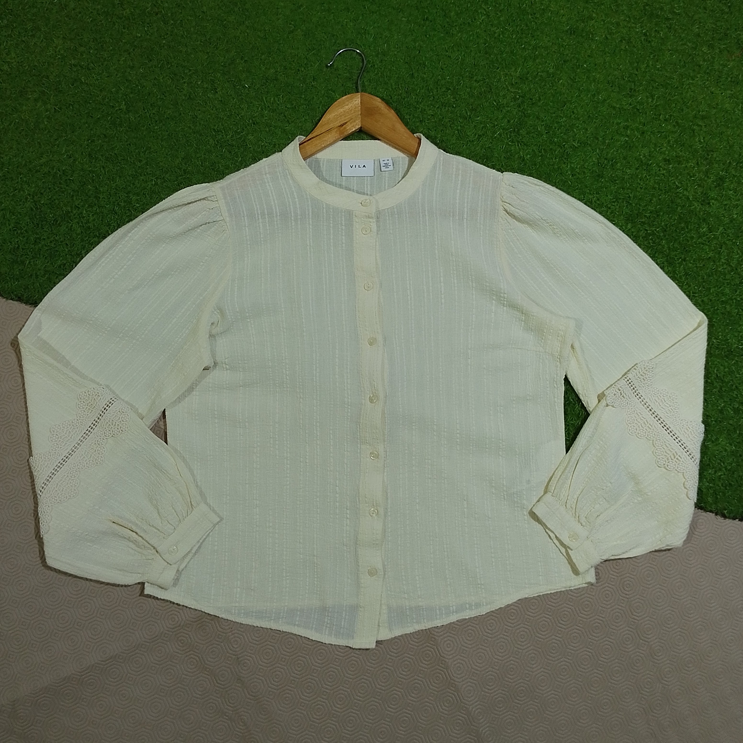Cream white button-front shirt with lace cuff detail