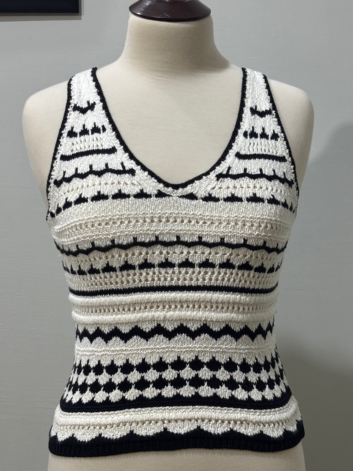 Front of black and white striped openwork sleeveless V-neck top