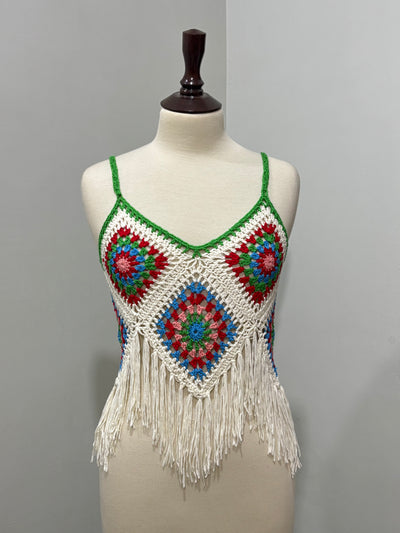 Front of cream and multicolor floral crochet strappy top with green trim and fringe hem
