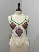 Front of cream and multicolor floral crochet strappy top with green trim and fringe hem