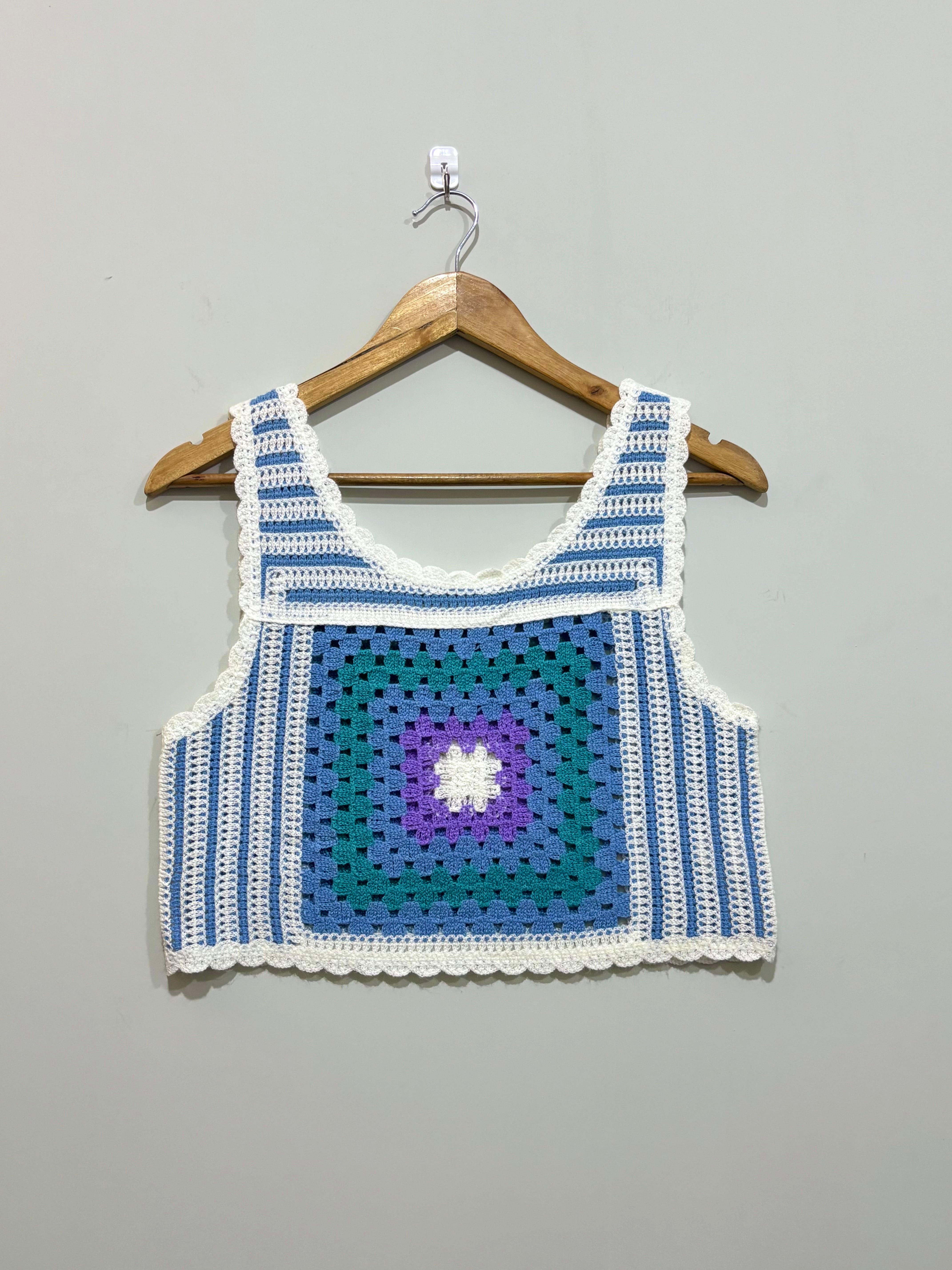 Blue and white granny-square crochet crop top with purple center and scalloped edges