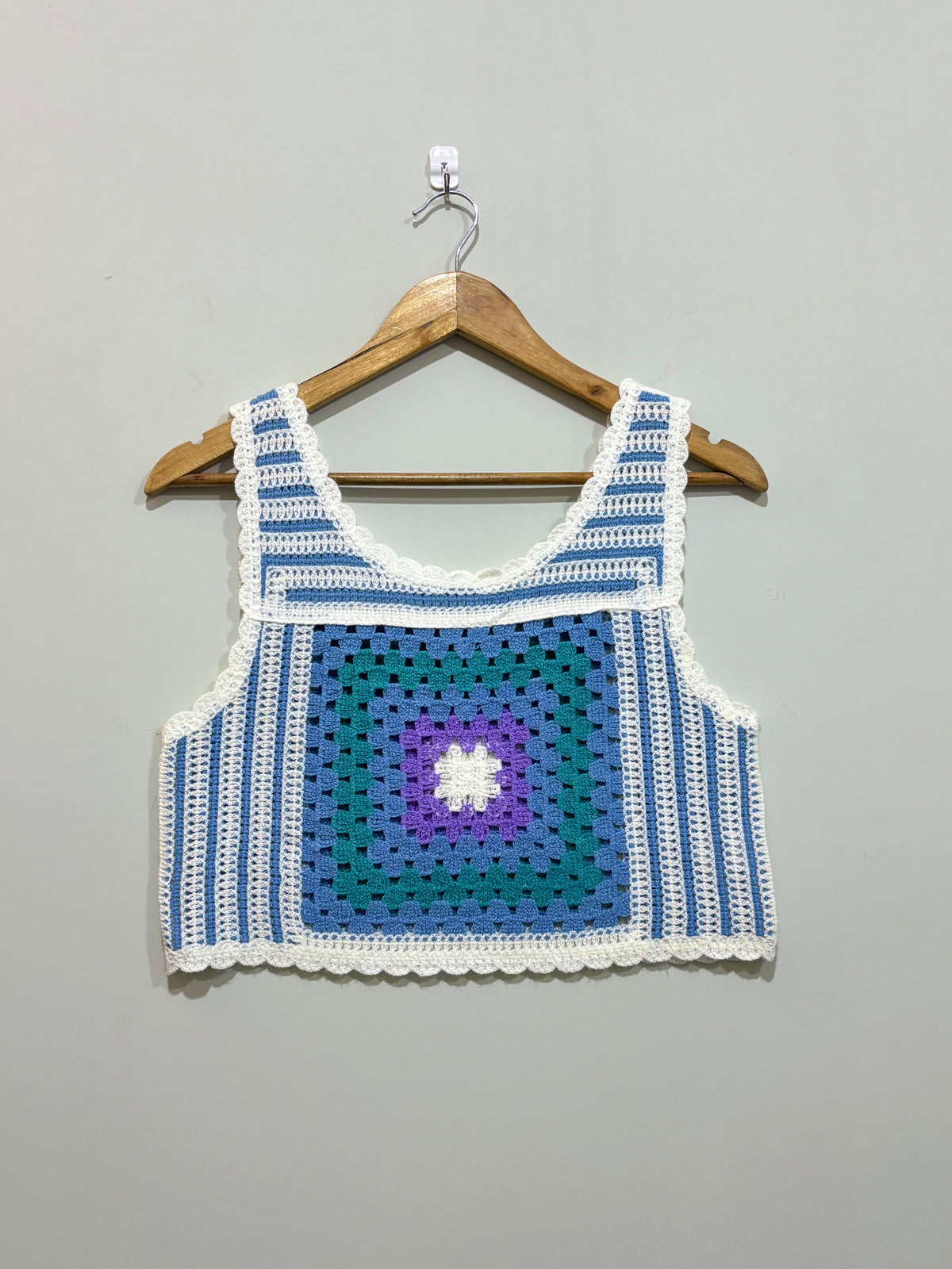 Blue and white granny-square crochet crop top with purple center and scalloped edges