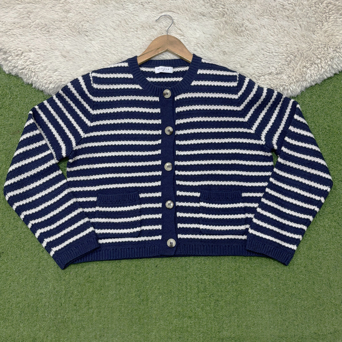 Navy and white horizontally striped round-neck cardigan with five contrast buttons, two patch pockets, long sleeves and navy ribbed trims.
