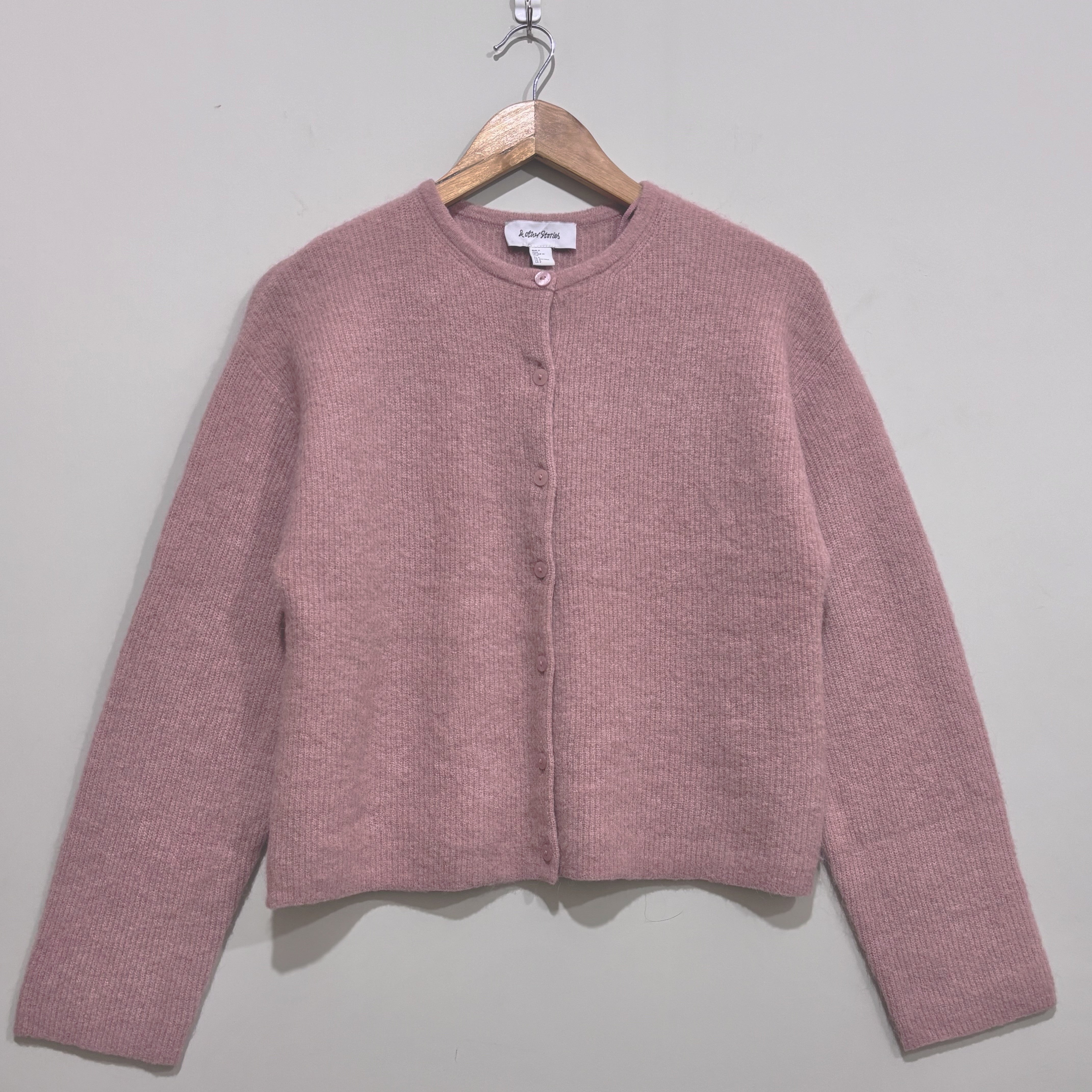Dusty pink round-neck button-front cardigan with dropped shoulders, long sleeves and a straight hem.