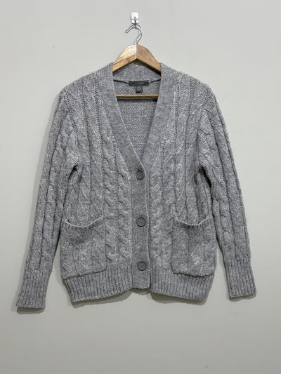 Grey cable-knit V-neck cardigan with three front buttons, two patch pockets, long sleeves and ribbed cuffs and hem.