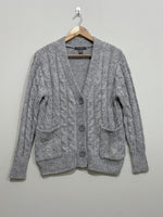 Grey cable-knit V-neck cardigan with three front buttons, two patch pockets, long sleeves and ribbed cuffs and hem.