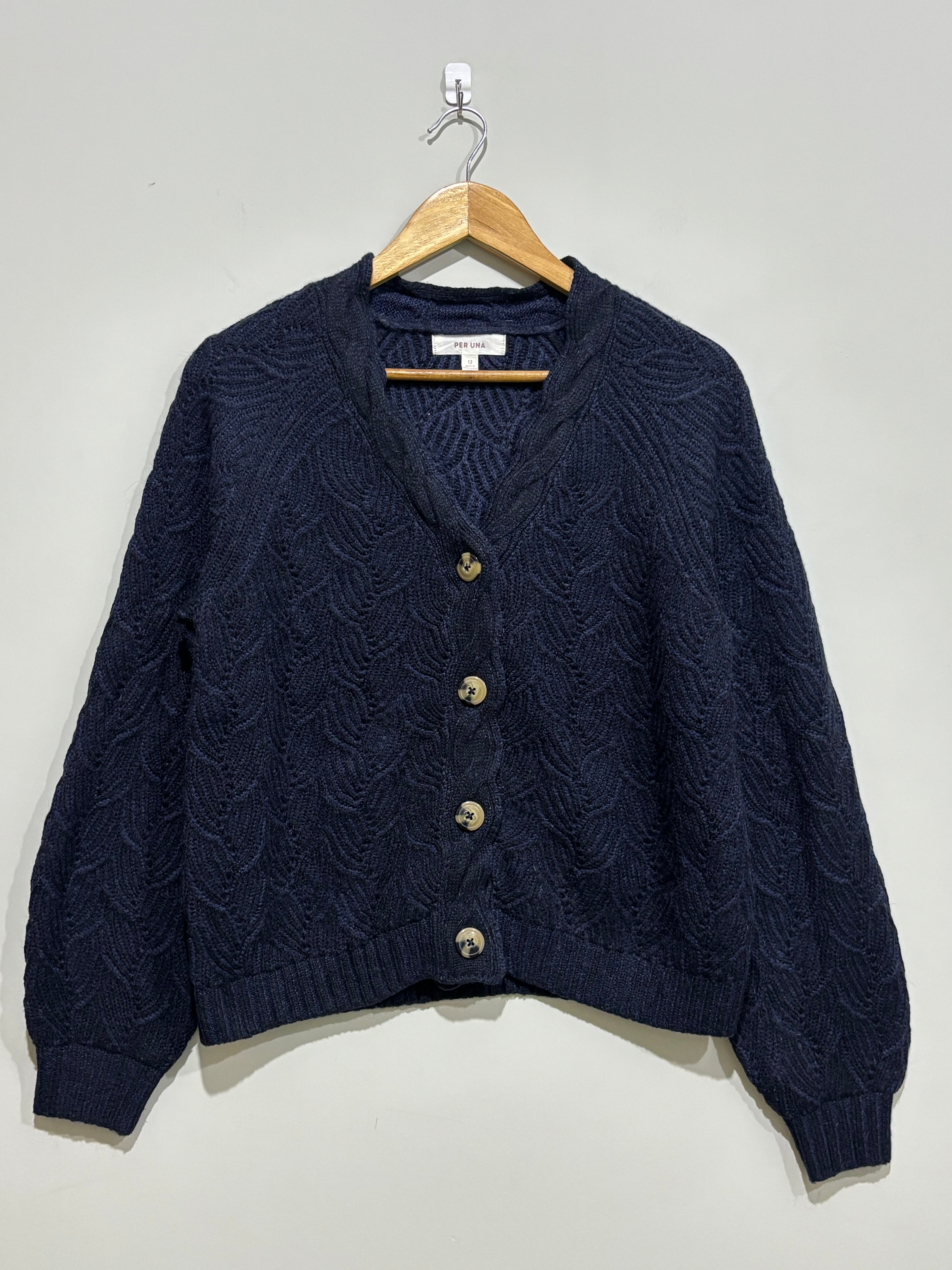 Navy cable-knit V-neck cardigan with four contrasting buttons, long raglan sleeves and ribbed cuffs and hem.