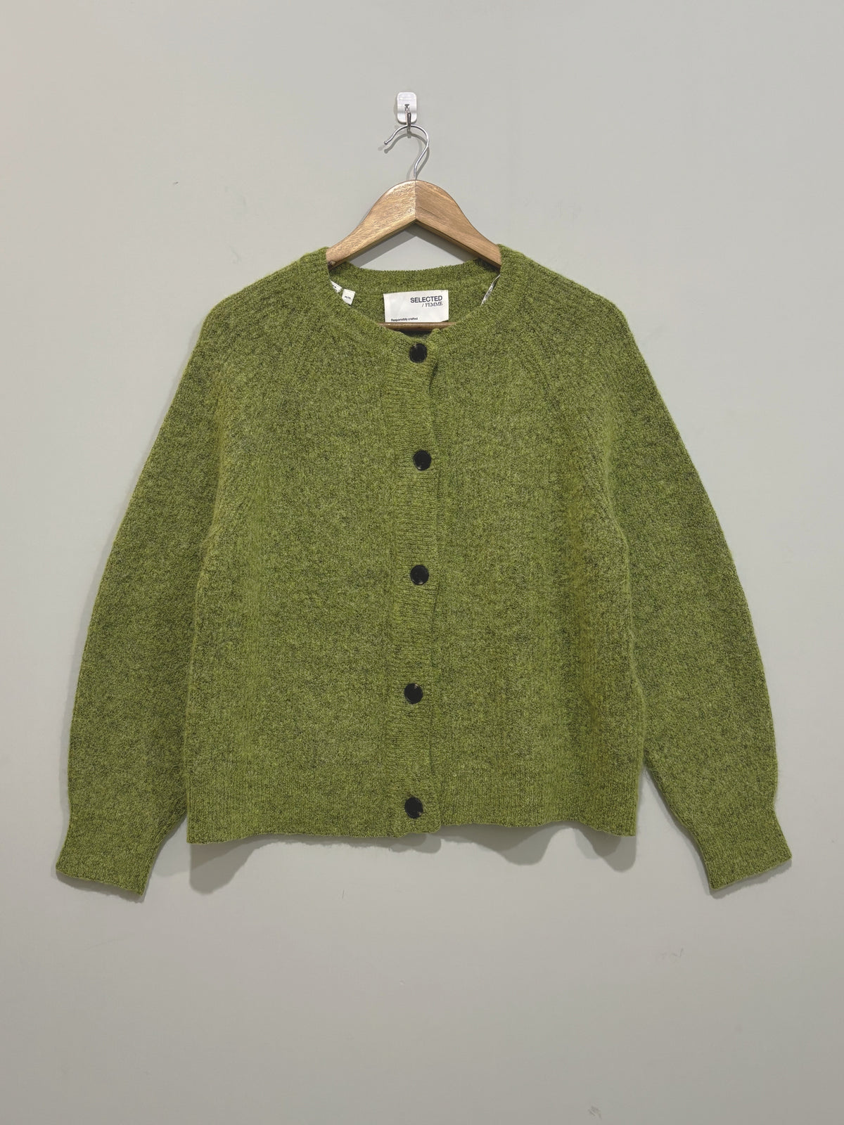 Olive green round-neck cardigan with five dark front buttons, long sleeves and ribbed trims on a wooden hanger.