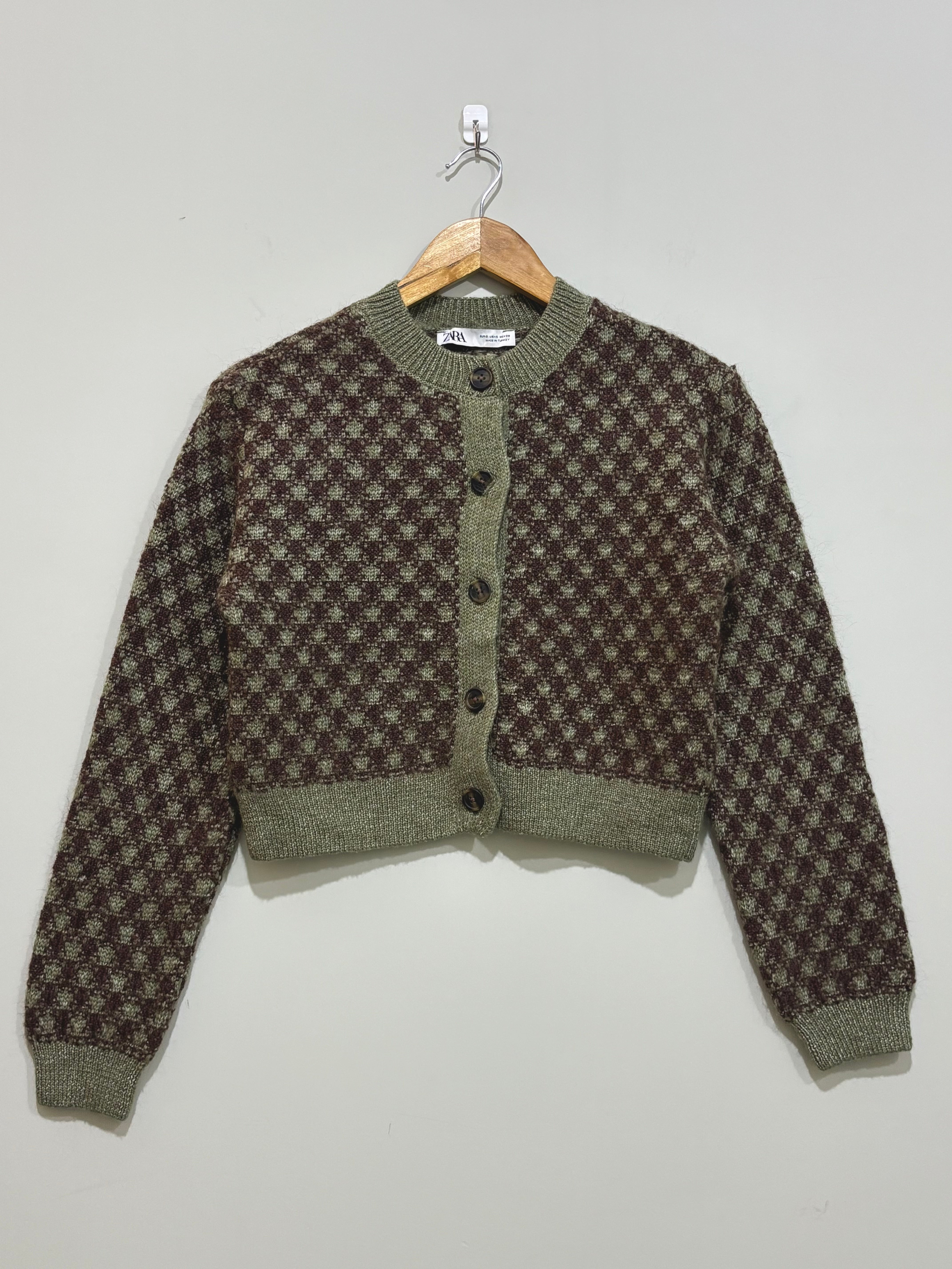 Olive green and brown geometric patterned cropped cardigan with a round neckline, front buttons and ribbed trims.