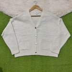 Light natural V-neck cardigan with dropped shoulders, four gold-tone buttons, two patch pockets and ribbed cuffs and hem.