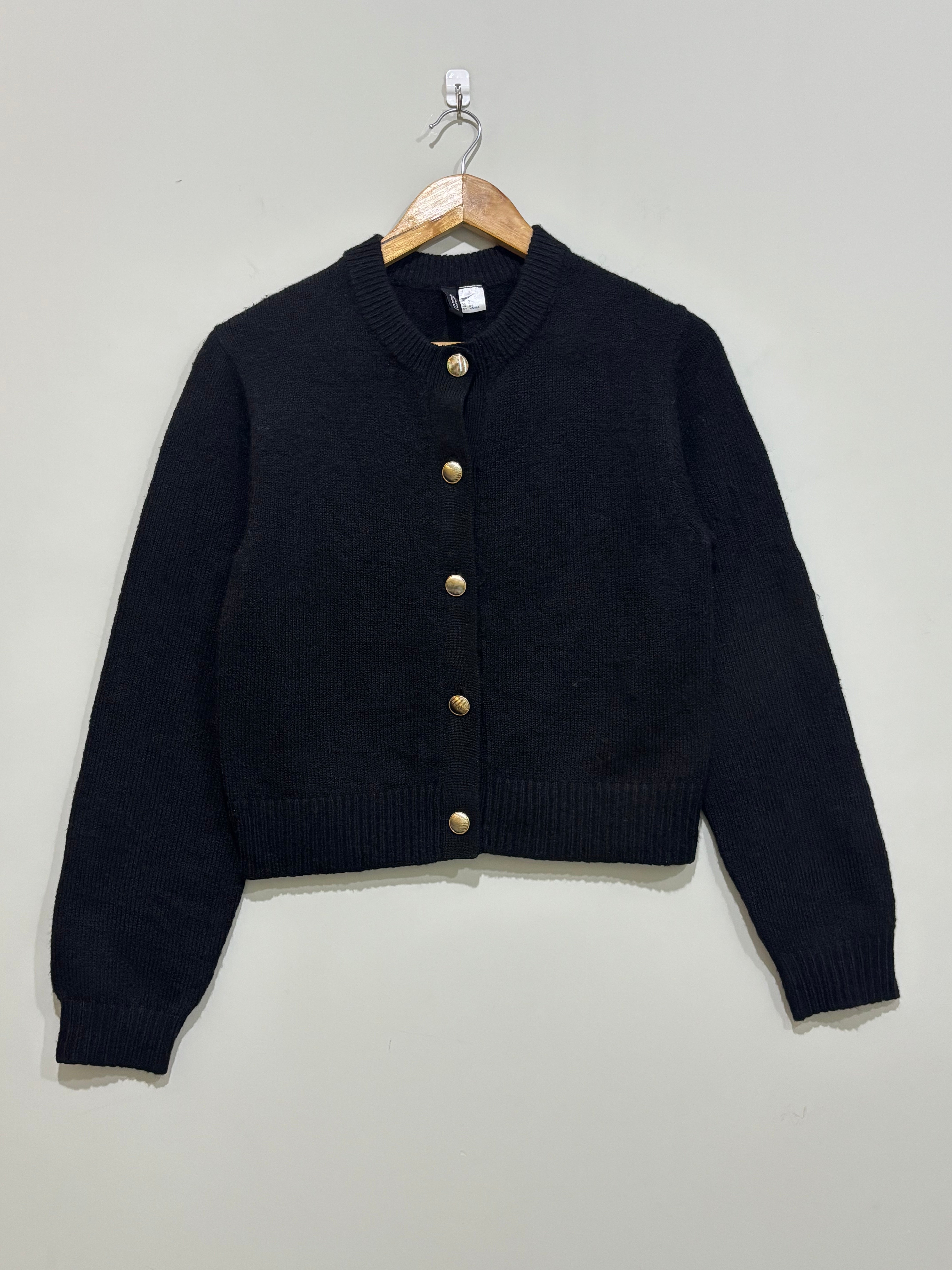Black cropped round-neck cardigan with five gold-tone front buttons, long sleeves and ribbed cuffs and hem.
