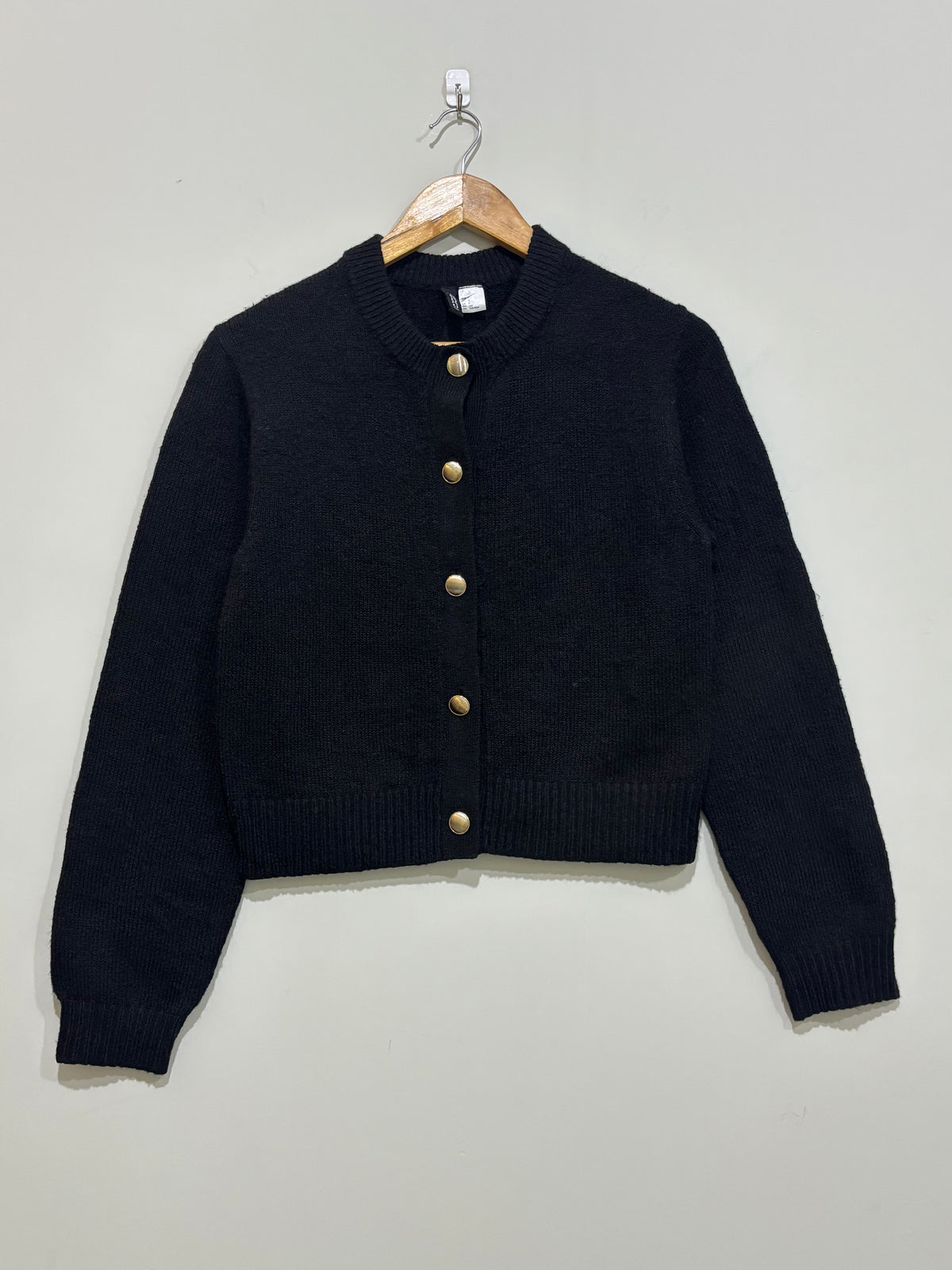 Black cropped round-neck cardigan with five gold-tone front buttons, long sleeves and ribbed cuffs and hem.