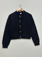 Black cropped round-neck cardigan with five gold-tone front buttons, long sleeves and ribbed cuffs and hem.
