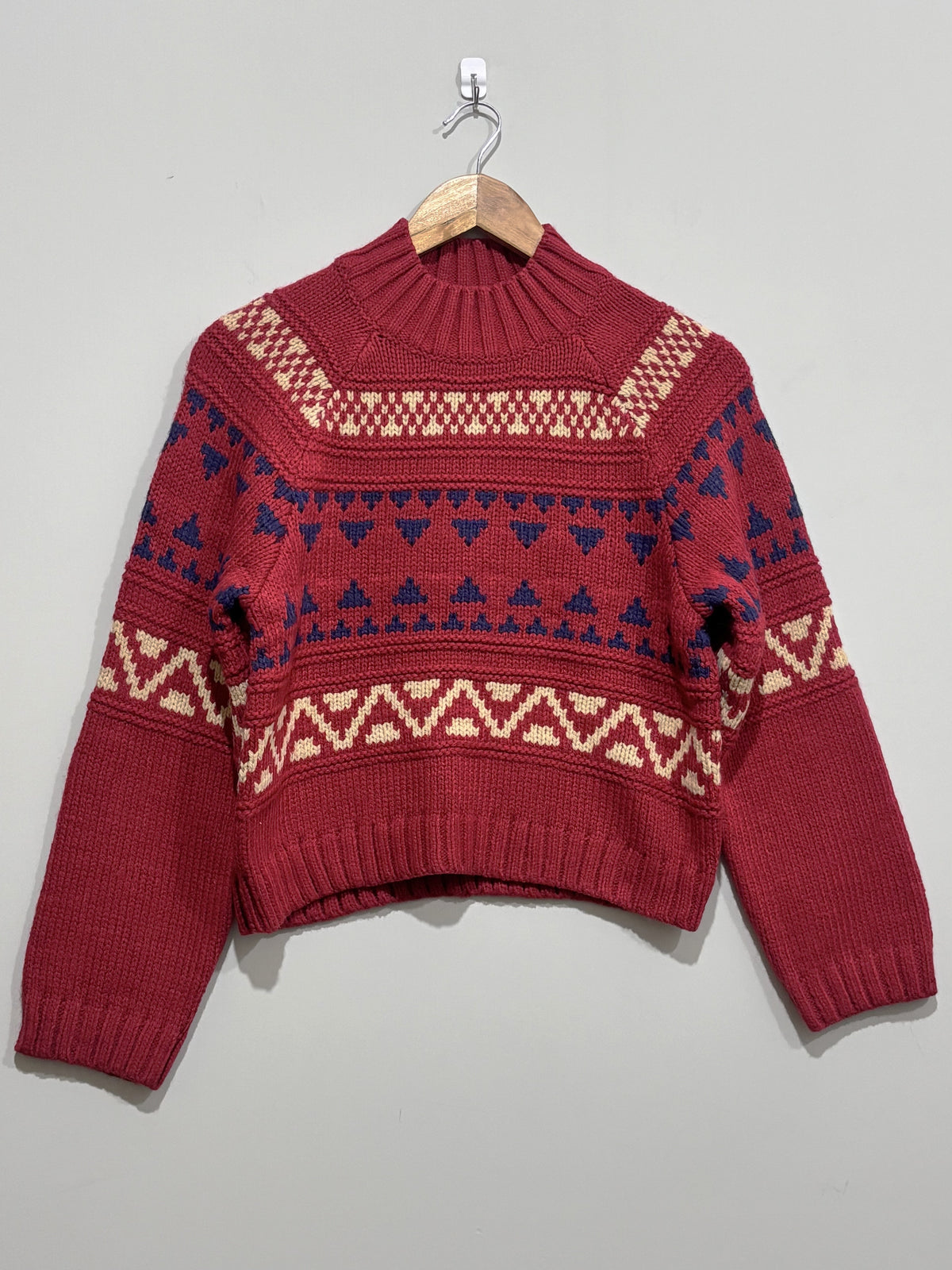 Burgundy high-neck knitted pullover with cream and navy geometric pattern bands, long sleeves and ribbed cuffs and hem.