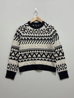 Black and cream geometric patterned winter pullover with cable-knit bands, a crew neck, long sleeves and black ribbed trims.