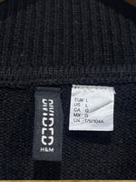 H&M Divided label showing EUR L and US L on the black knitted blouse.
