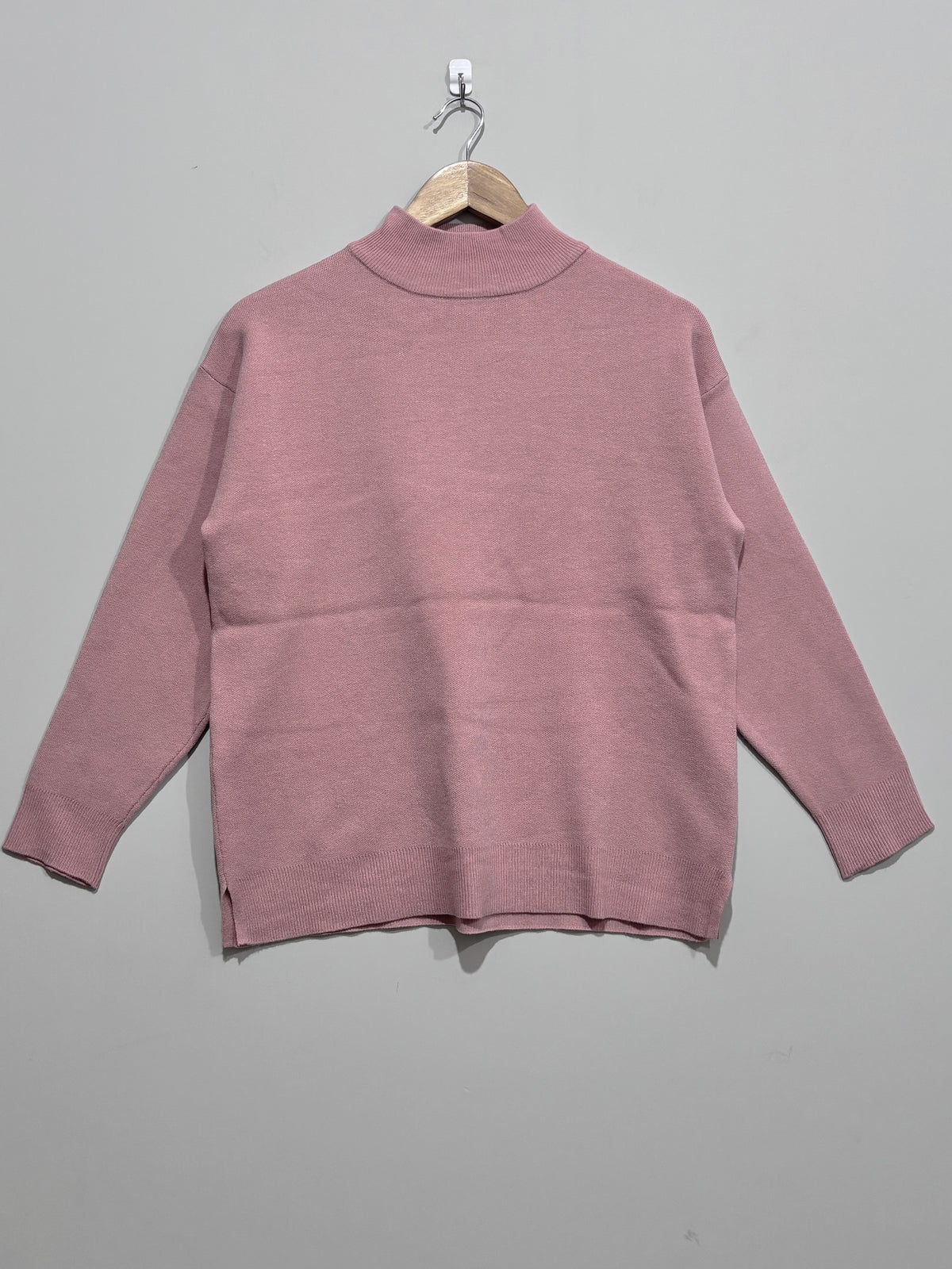 Dusty pink high-neck pullover with dropped shoulders, long sleeves, ribbed cuffs and hem, and side slits.