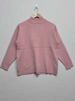 Dusty pink high-neck pullover with dropped shoulders, long sleeves, ribbed cuffs and hem, and side slits.