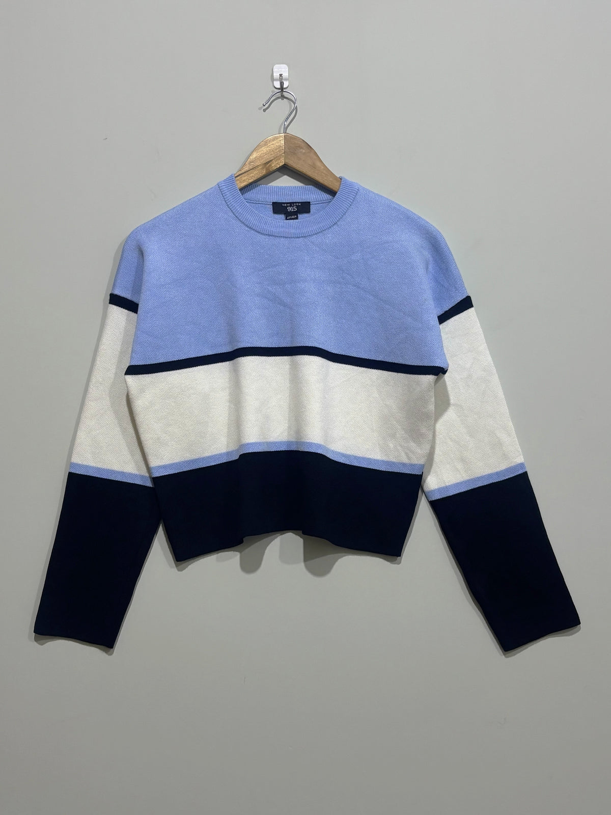Light blue, cream and navy color-block crew-neck pullover with narrow contrast stripes, dropped shoulders and long sleeves.