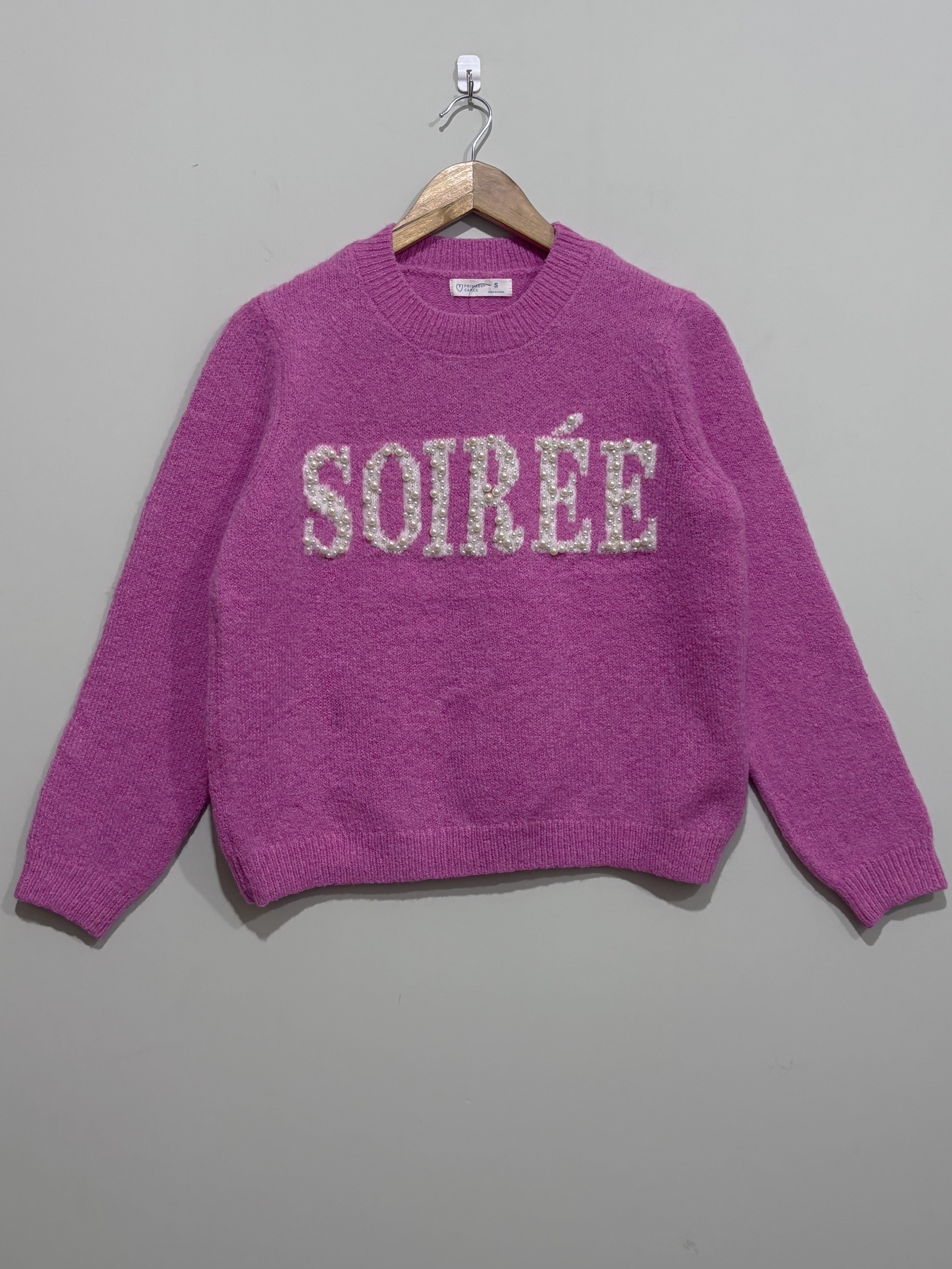 Pink crew-neck knitted blouse with sparkling Soirée lettering across the chest, long sleeves and ribbed cuffs and hem.