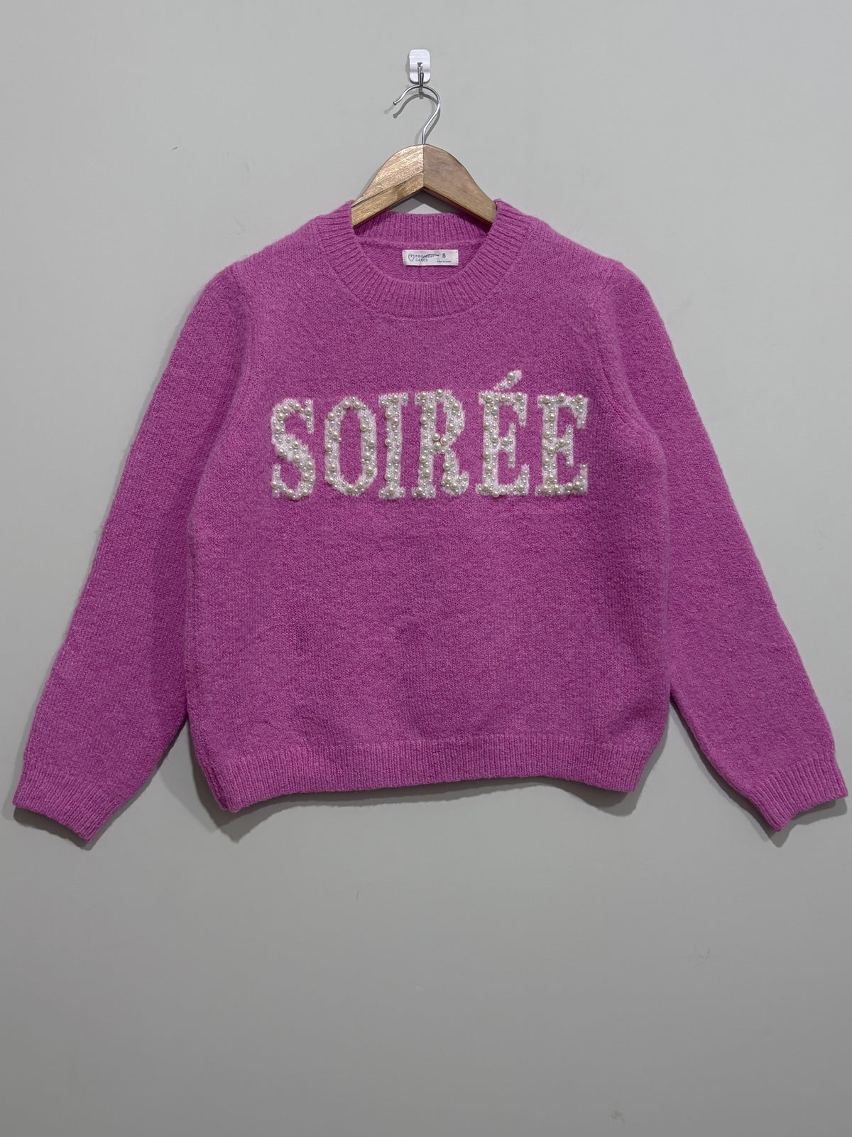 Pink crew-neck knitted blouse with sparkling Soirée lettering across the chest, long sleeves and ribbed cuffs and hem.