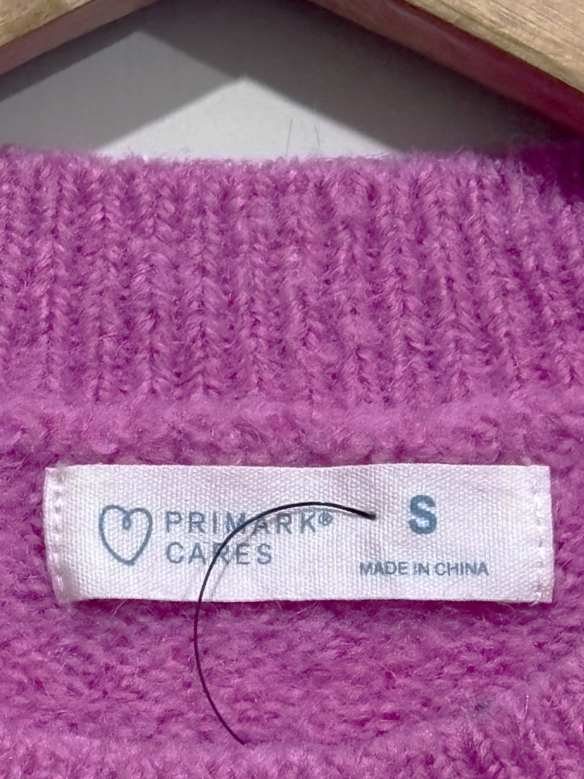 Primark Cares label showing size S on the pink knitted blouse.