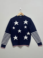 Navy blue crew-neck winter blouse with white stars, white striped sleeves and pink edging at the cuffs and hem.