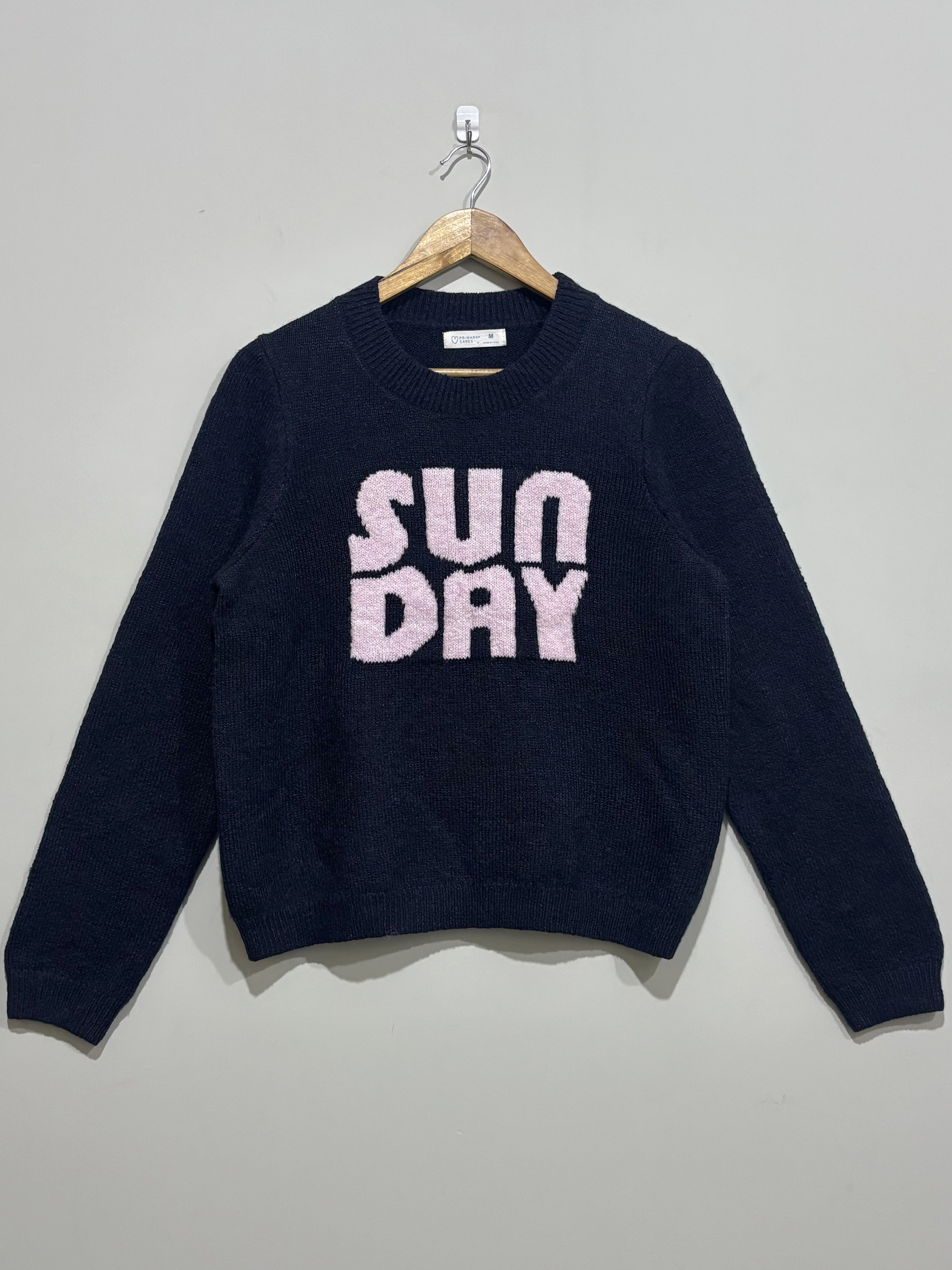 Navy blue crew-neck winter blouse with textured pink Sunday lettering, long sleeves and ribbed cuffs and hem.