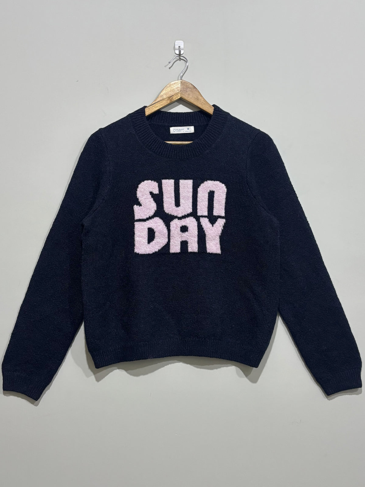 Navy blue crew-neck winter blouse with textured pink Sunday lettering, long sleeves and ribbed cuffs and hem.