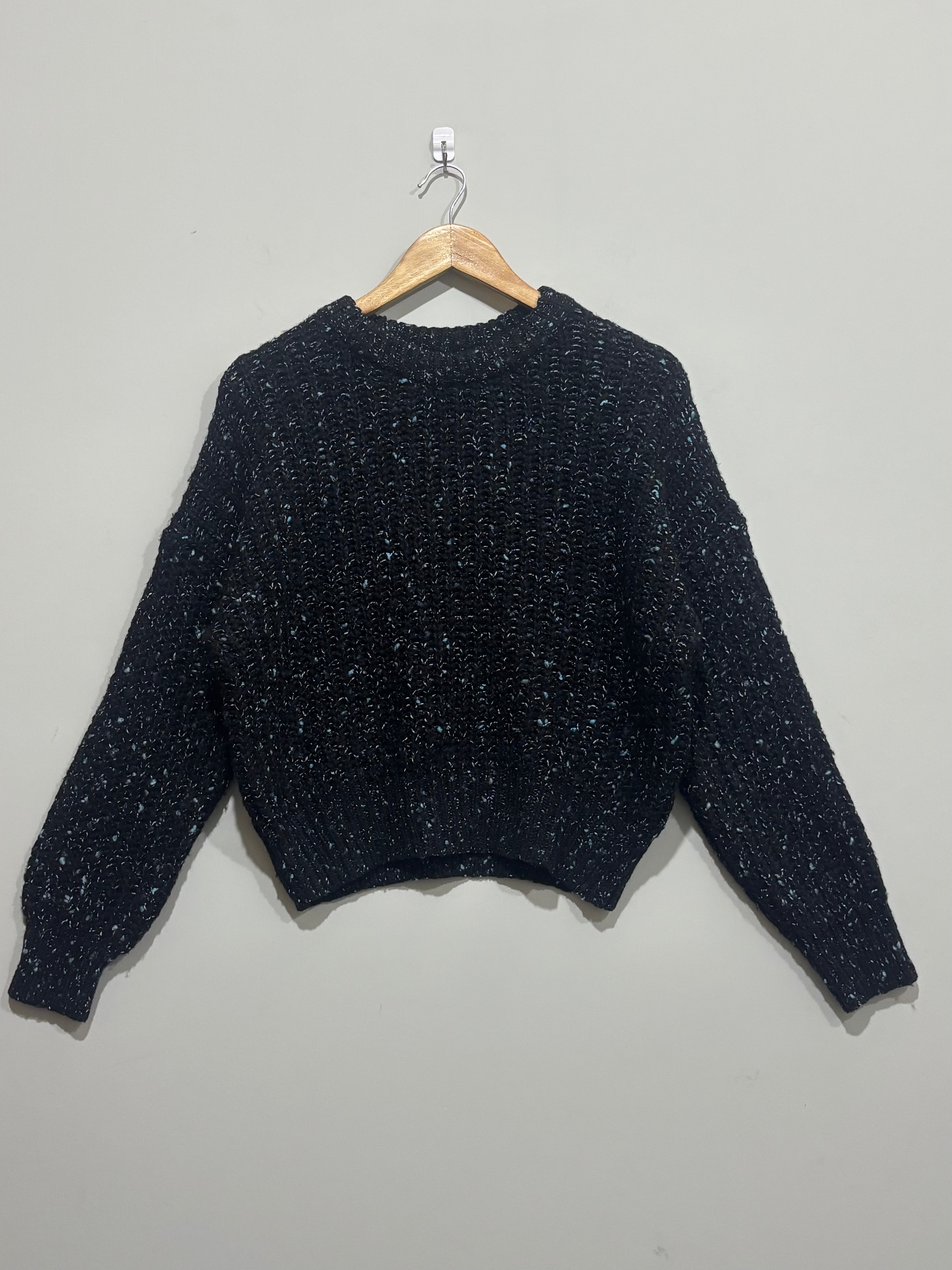 Black textured crew-neck winter blouse with light flecks, dropped shoulders, long sleeves and ribbed trims.