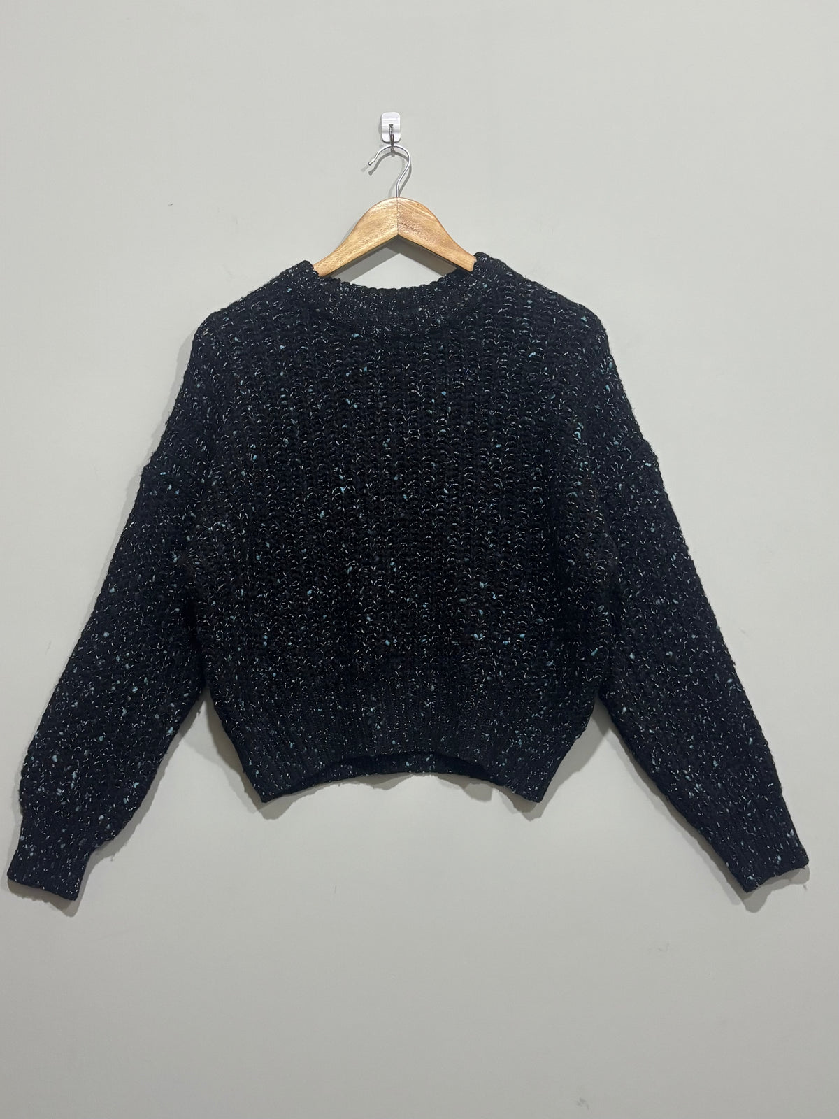 Black textured crew-neck winter blouse with light flecks, dropped shoulders, long sleeves and ribbed trims.