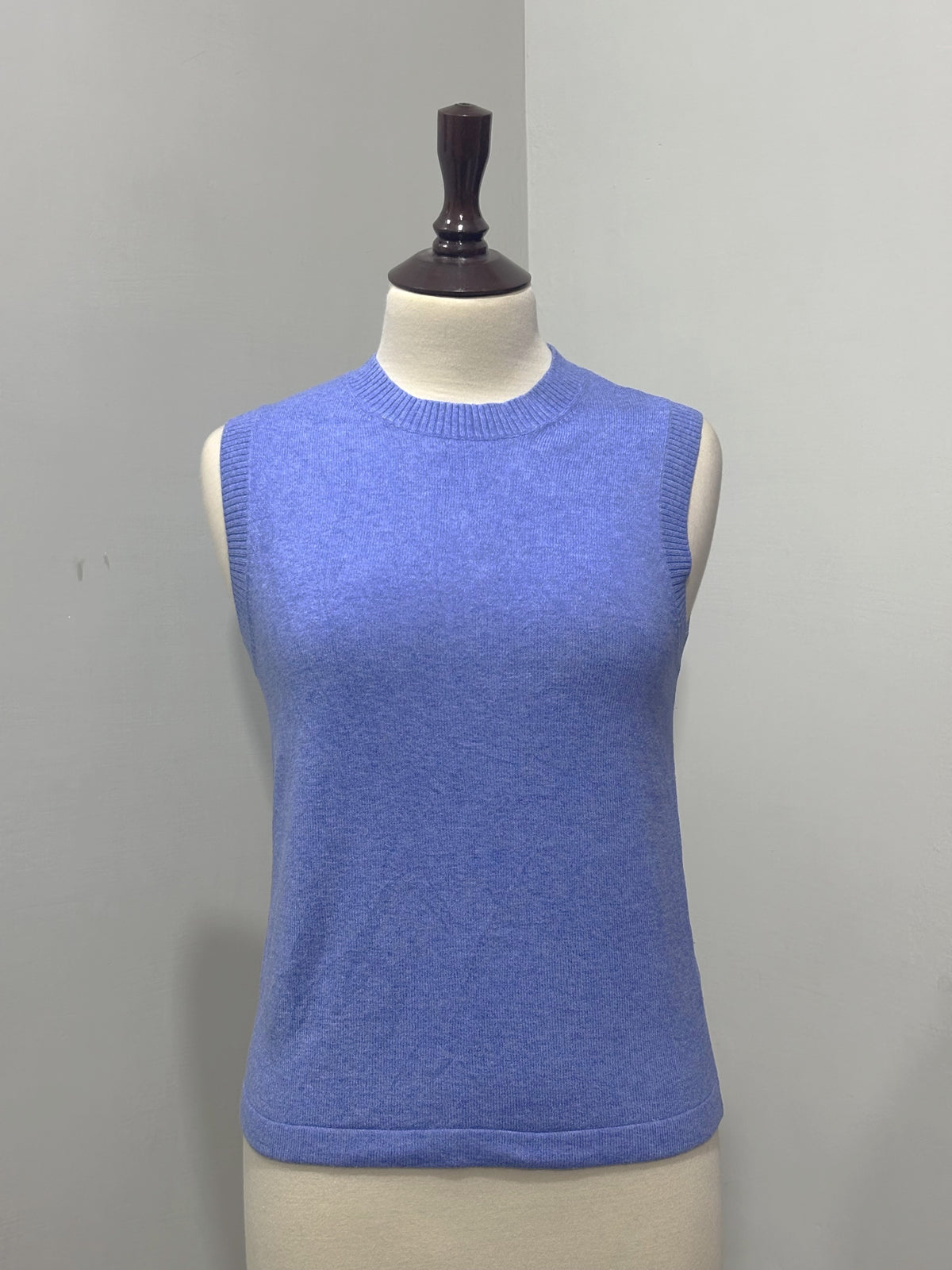 Periwinkle blue sleeveless crew-neck sweater vest displayed on a mannequin