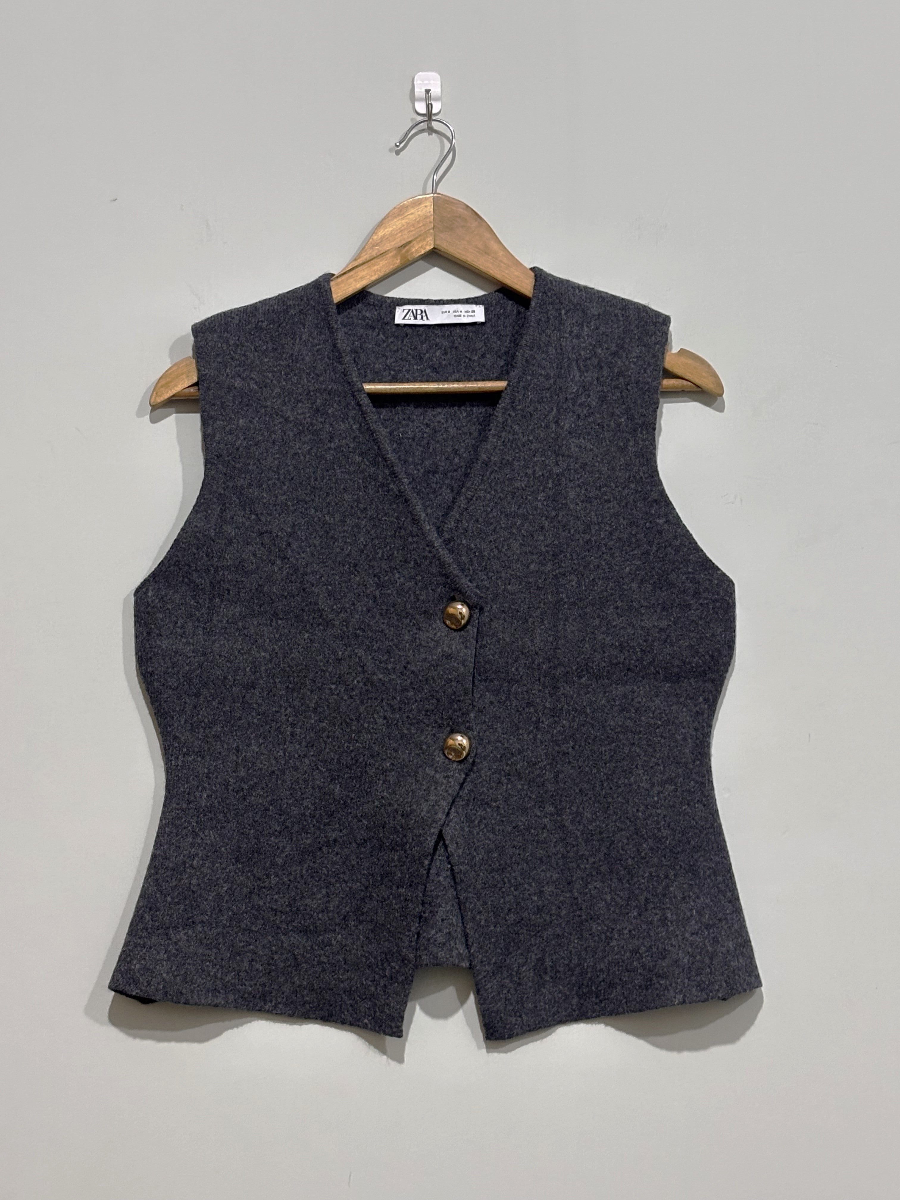 Charcoal grey V-neck sleeveless vest with two gold-tone buttons and shaped waist