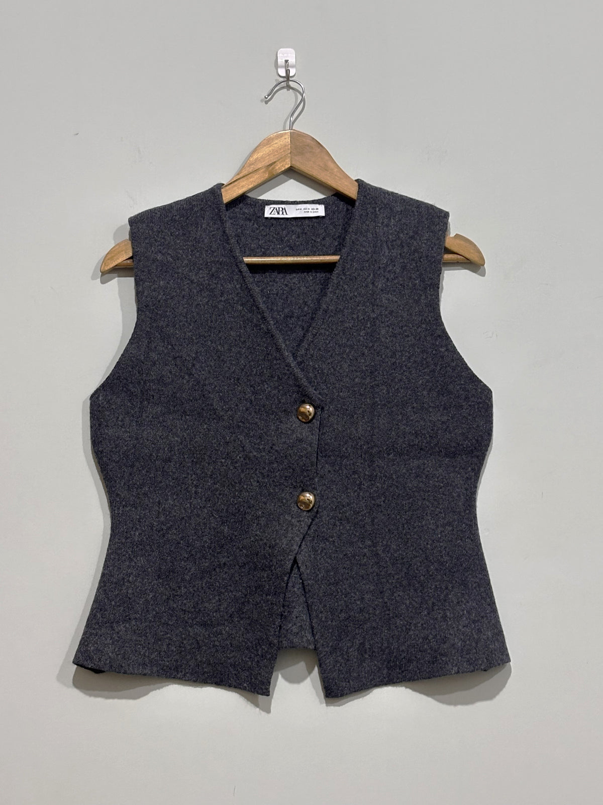 Charcoal grey V-neck sleeveless vest with two gold-tone buttons and shaped waist