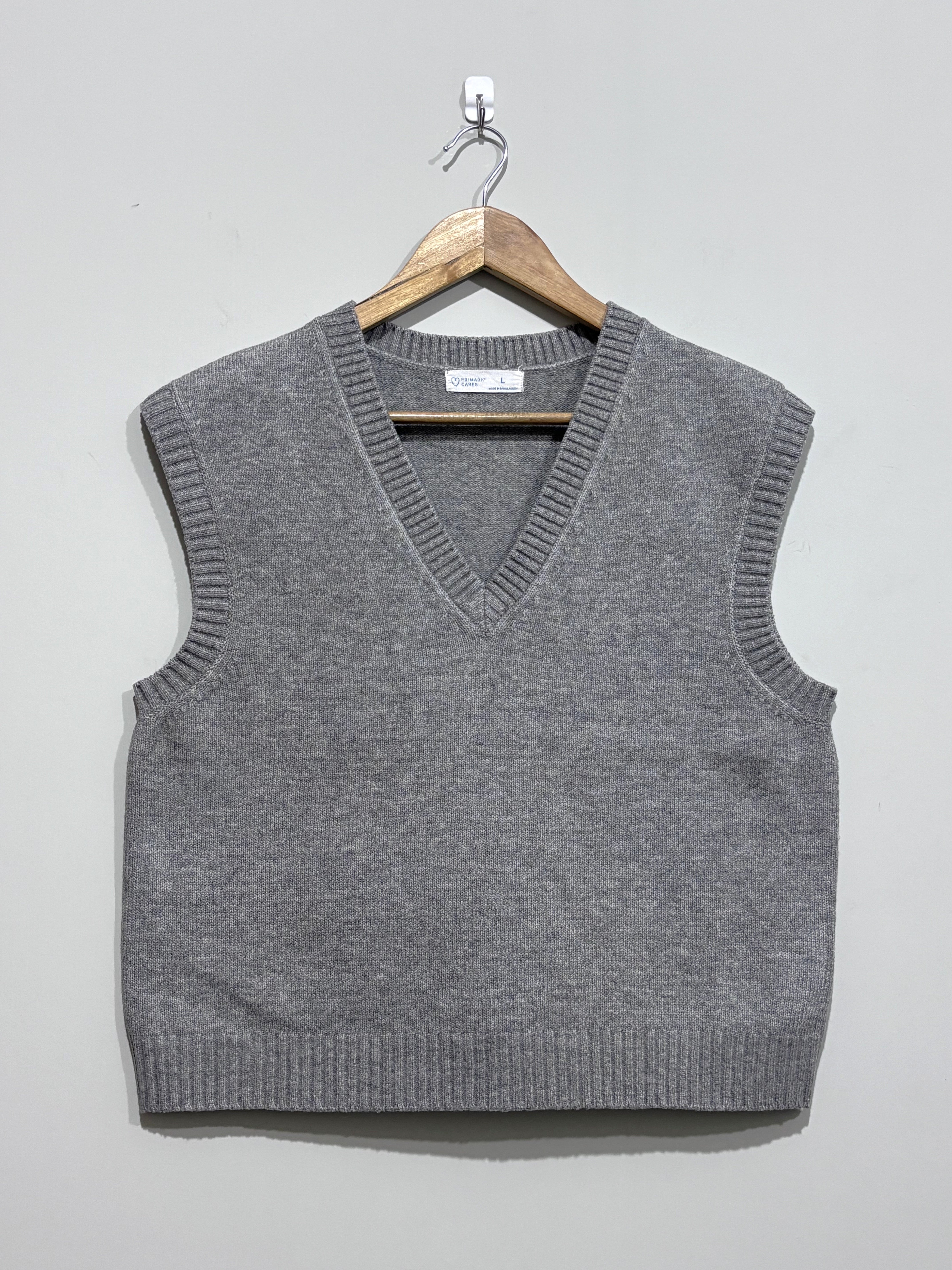 Grey sleeveless V-neck sweater vest with ribbed neckline, armholes and hem