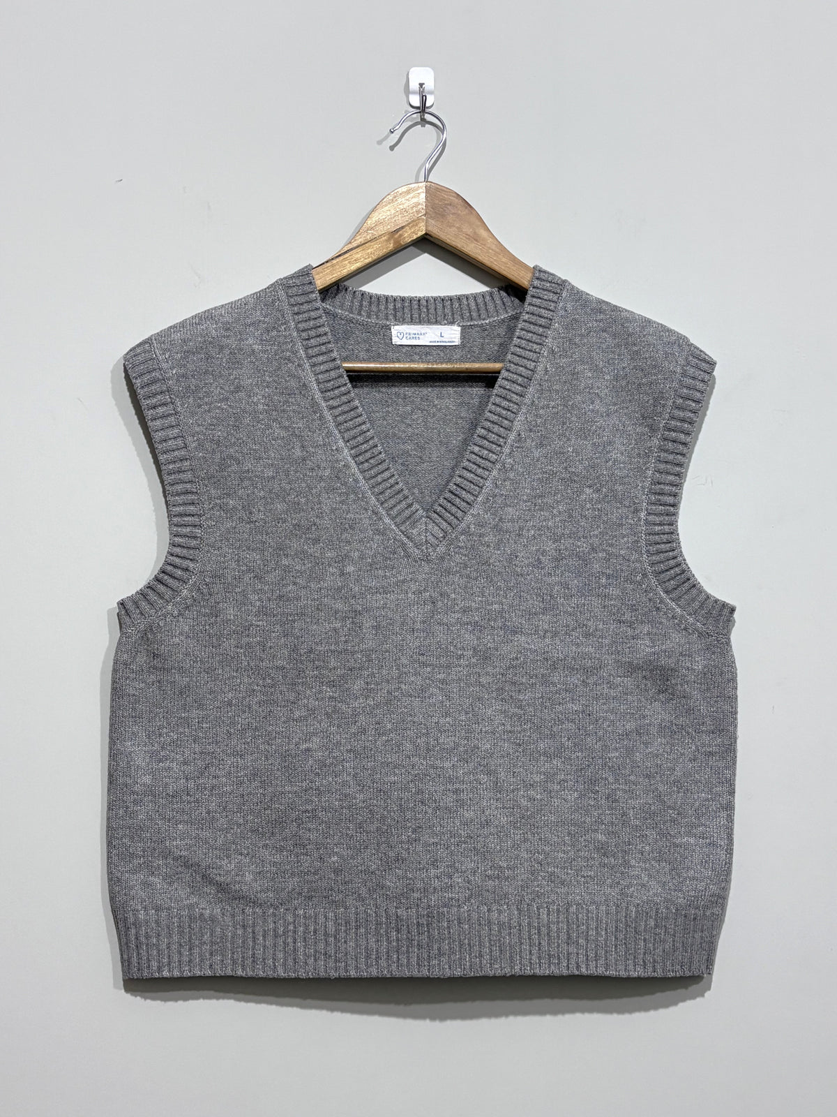 Grey sleeveless V-neck sweater vest with ribbed neckline, armholes and hem