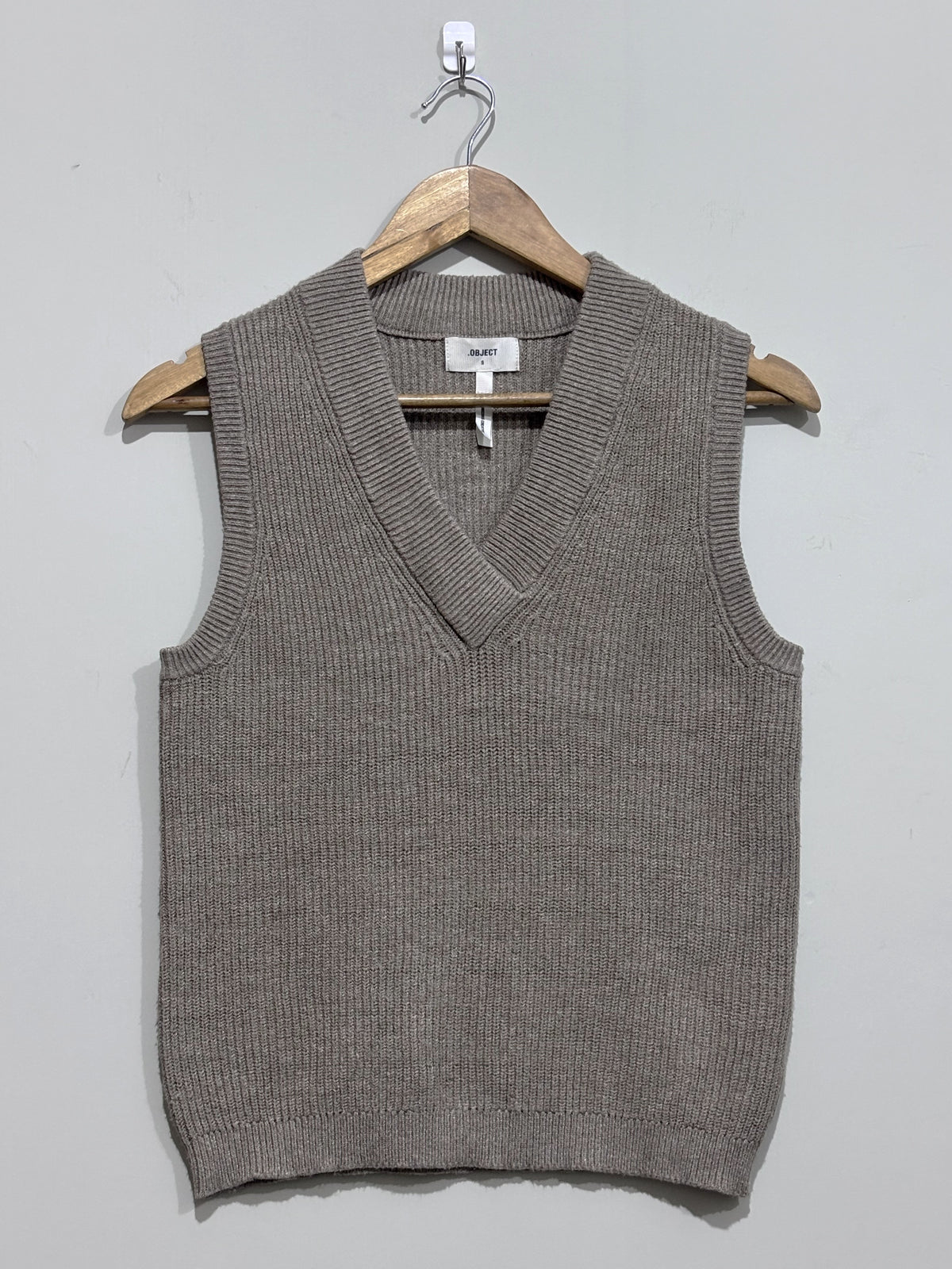 Taupe textured sleeveless sweater vest with a deep V-neck and ribbed edging