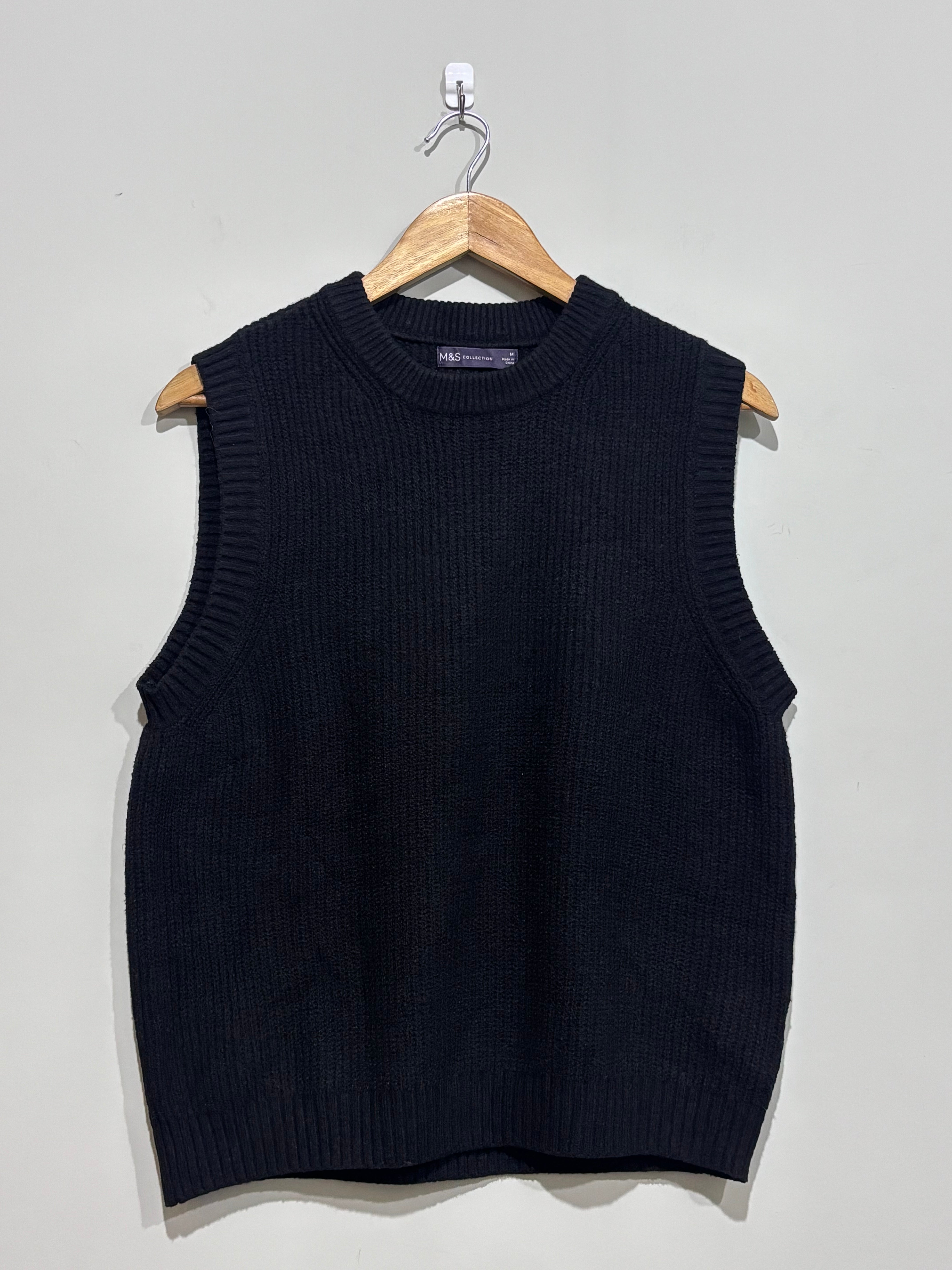 Black sleeveless crew-neck sweater vest with textured stitching and ribbed edging