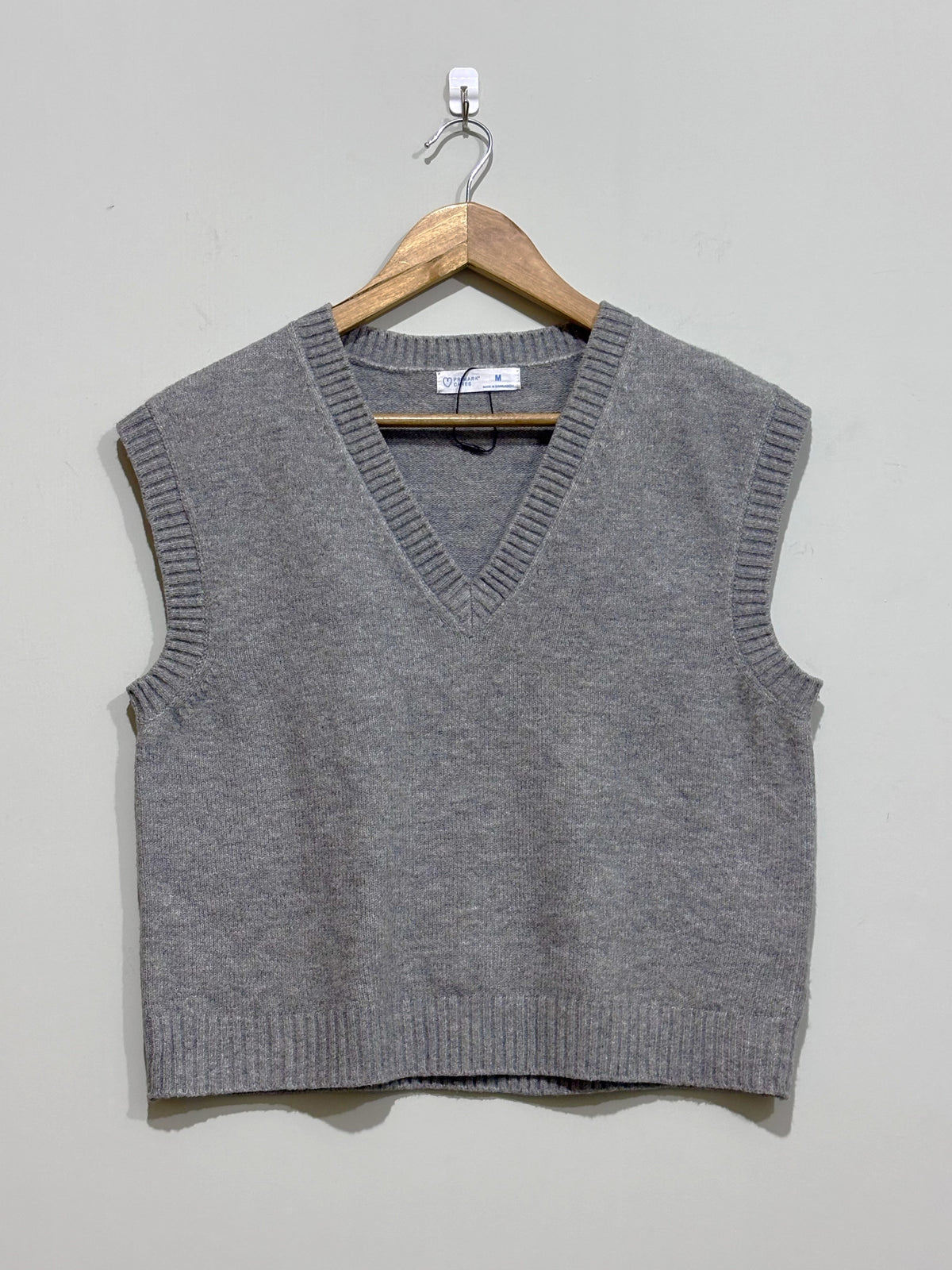 Grey V-neck sleeveless sweater vest with ribbed neckline, armholes and hem