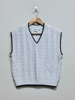 White cable-knit V-neck vest with black contrast trim