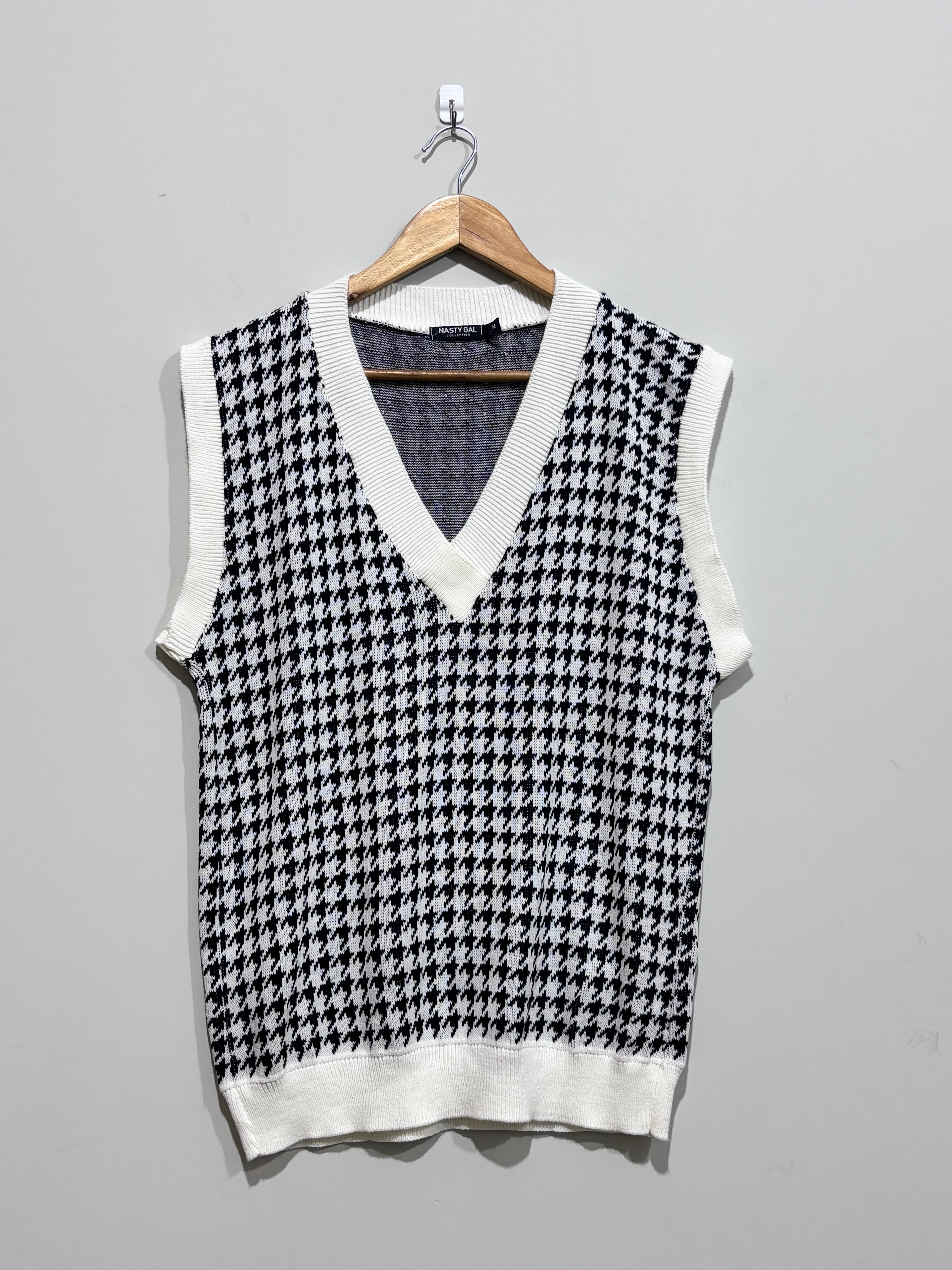 Black and white houndstooth V-neck sweater vest with white ribbed trim